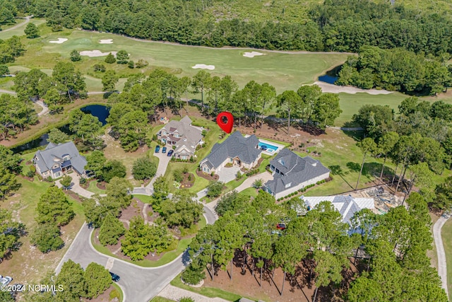 drone / aerial view with view of golf course, a water view, and a residential view