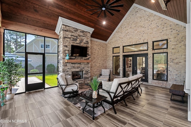 living room featuring high vaulted ceiling, wooden ceiling, a fireplace, french doors, and crown molding