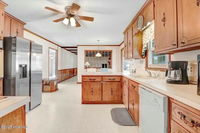 kitchen featuring dishwasher, ornamental molding, light countertops, stainless steel refrigerator with ice dispenser, and a sink