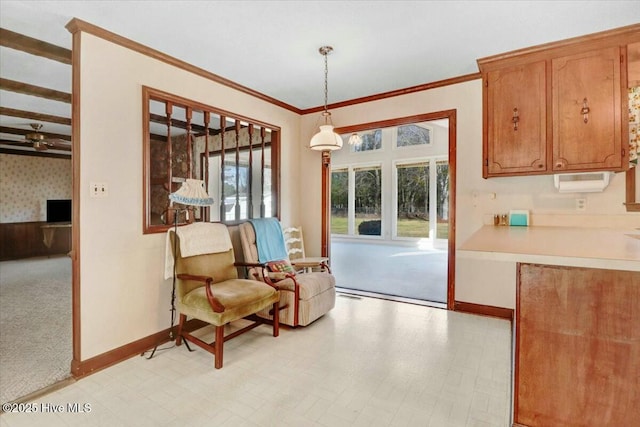 living area featuring a healthy amount of sunlight, baseboards, and crown molding