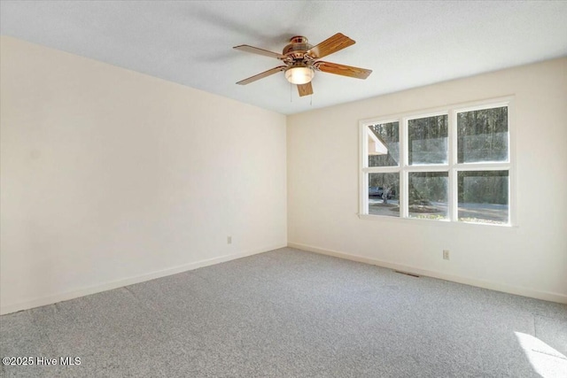 spare room featuring baseboards, visible vents, ceiling fan, and carpet flooring