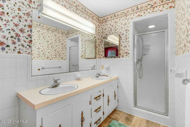bathroom with a wainscoted wall, a sink, and wallpapered walls