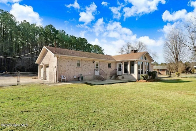 rear view of property featuring entry steps, a lawn, a chimney, and fence
