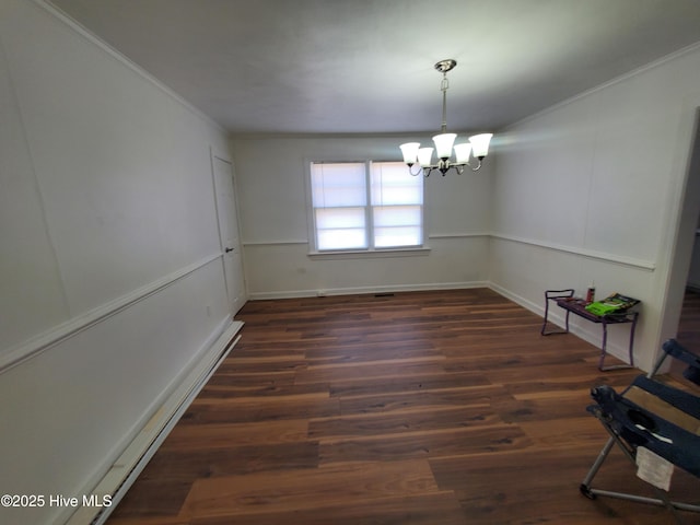 unfurnished dining area with dark wood-type flooring, ornamental molding, a decorative wall, and an inviting chandelier