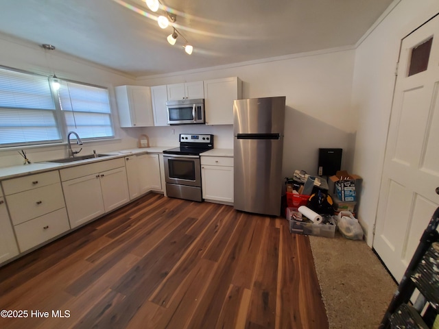 kitchen featuring dark wood-type flooring, stainless steel appliances, light countertops, white cabinetry, and a sink