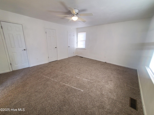 unfurnished bedroom featuring baseboards, visible vents, ceiling fan, and carpet flooring