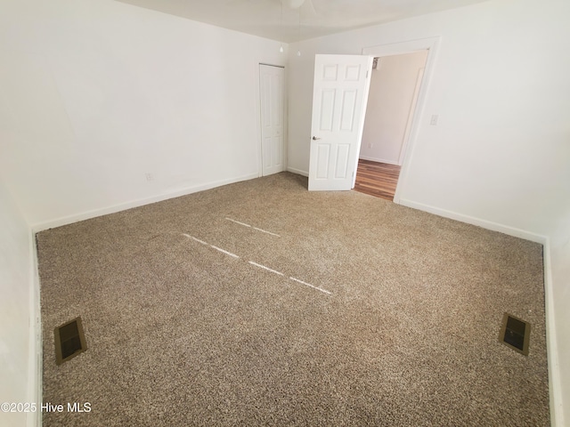 unfurnished bedroom with baseboards, a closet, visible vents, and carpet flooring