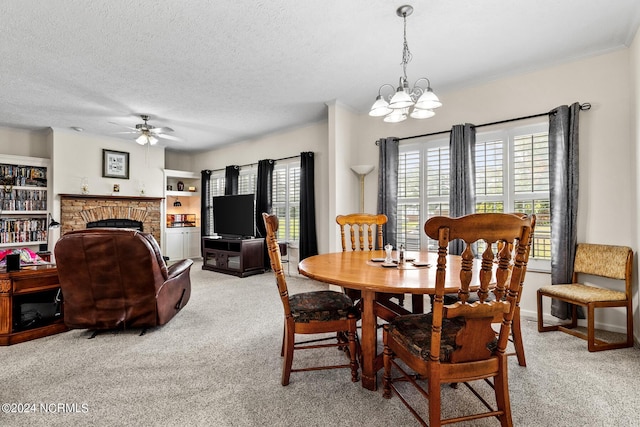 dining area featuring ornamental molding, a brick fireplace, carpet flooring, a textured ceiling, and ceiling fan with notable chandelier