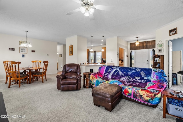 living room featuring carpet, a ceiling fan, and a textured ceiling