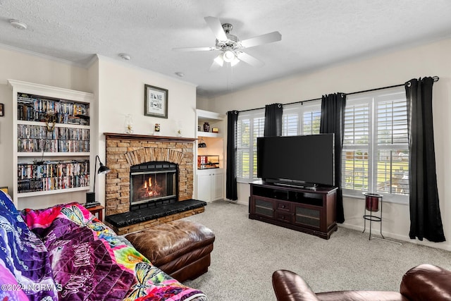 living area featuring carpet floors, crown molding, a fireplace, a ceiling fan, and a textured ceiling