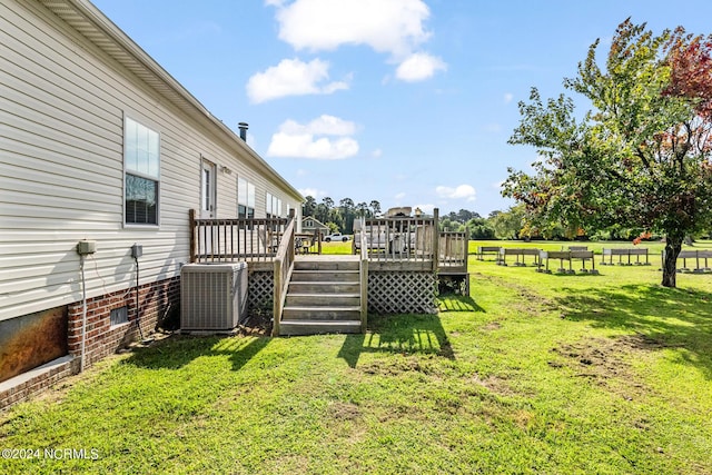 view of yard with a deck and central air condition unit