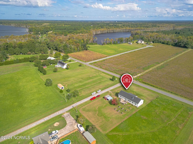 birds eye view of property featuring a water view, a view of trees, and a rural view