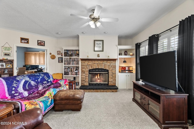 carpeted living area with ceiling fan, a fireplace, ornamental molding, and a textured ceiling