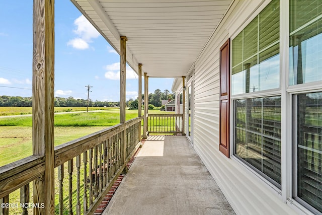 balcony featuring a porch and a rural view