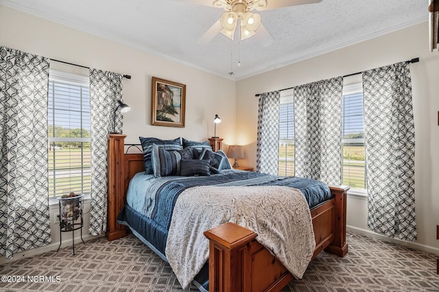 carpeted bedroom featuring baseboards, ornamental molding, and a ceiling fan