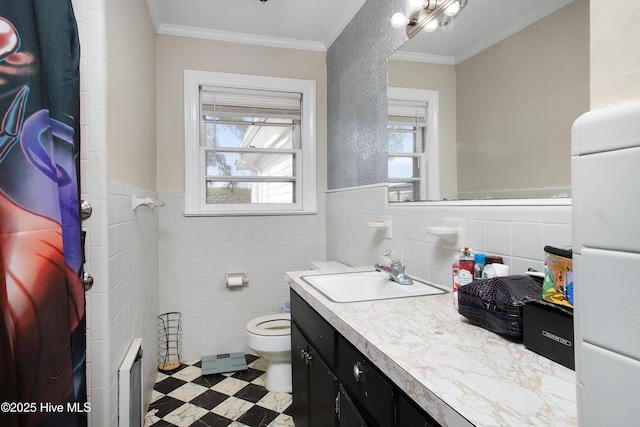 bathroom featuring tile patterned floors, toilet, tile walls, and crown molding