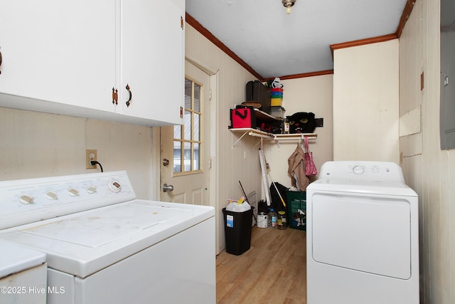 clothes washing area featuring cabinet space, separate washer and dryer, light wood-style flooring, and crown molding