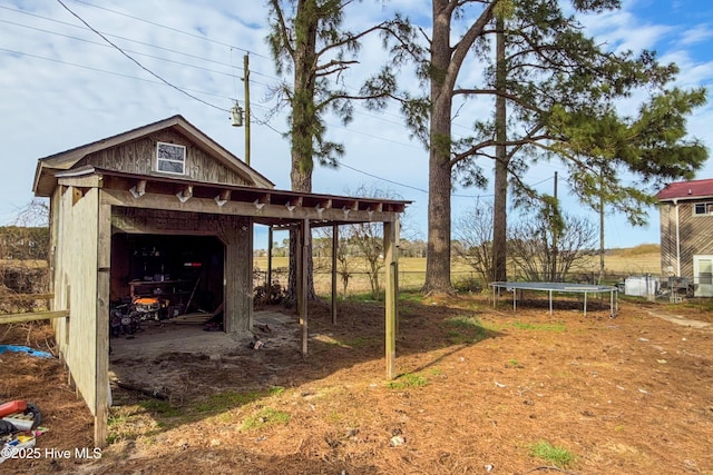 view of yard with a storage unit, an outbuilding, and a trampoline