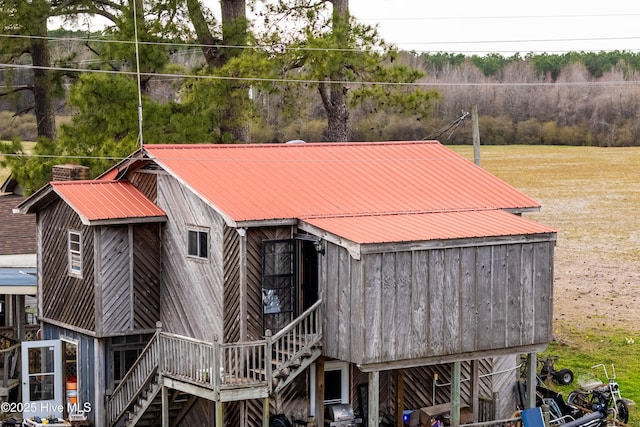 exterior space with stairway and metal roof