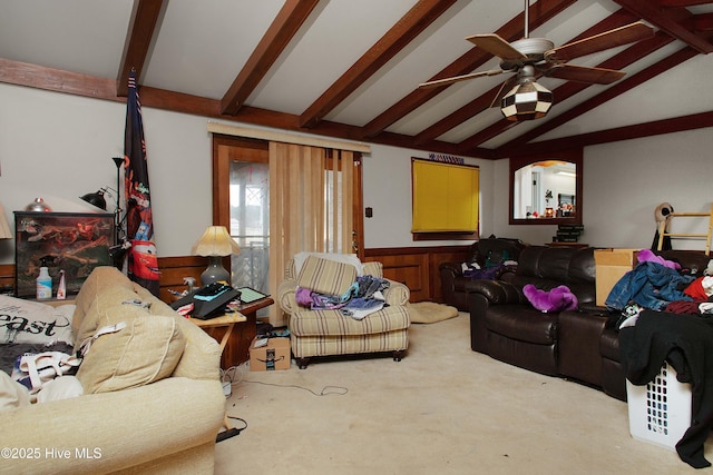 living area featuring vaulted ceiling with beams, a ceiling fan, a wainscoted wall, and carpet floors