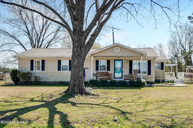 view of front facade featuring covered porch, a front yard, and a shingled roof