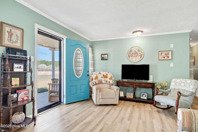 living area with a textured ceiling, wood finished floors, and ornamental molding