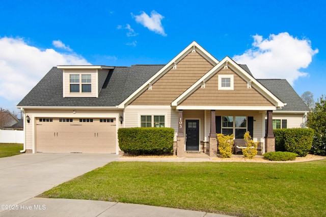 craftsman house featuring a shingled roof, a porch, concrete driveway, an attached garage, and a front yard