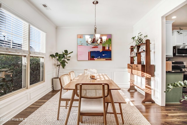 dining space featuring visible vents, a chandelier, dark wood-style flooring, and ornamental molding