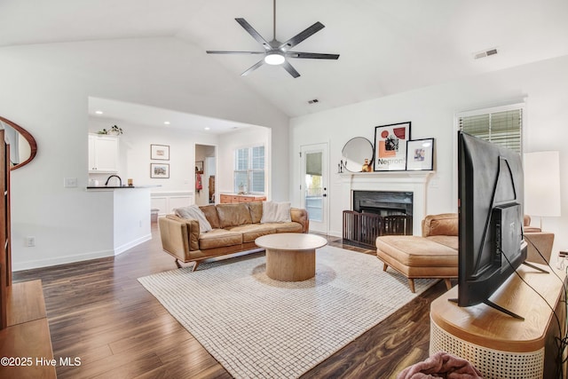 living room featuring visible vents, a ceiling fan, a fireplace with flush hearth, dark wood-type flooring, and high vaulted ceiling