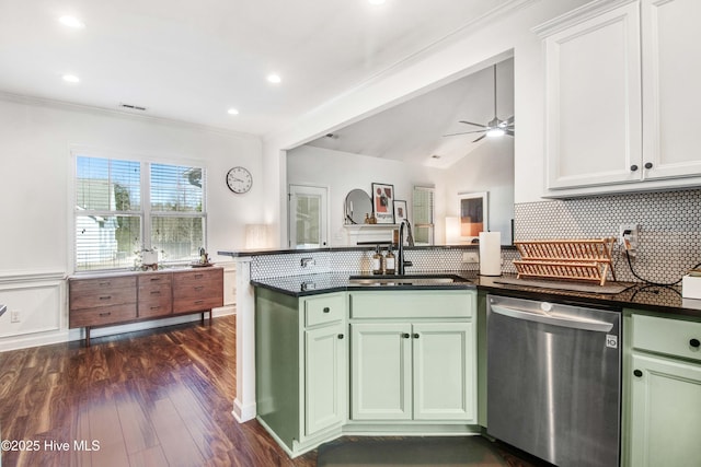 kitchen featuring a sink, a peninsula, green cabinets, and stainless steel dishwasher