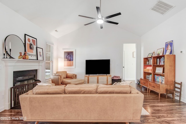 living room featuring dark wood-type flooring, visible vents, a fireplace, and ceiling fan