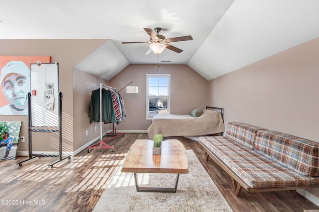 interior space featuring lofted ceiling, wood finished floors, and baseboards