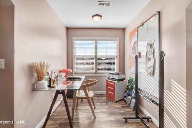 office space featuring baseboards, visible vents, and wood finished floors