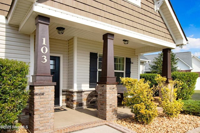 property entrance featuring covered porch and stone siding