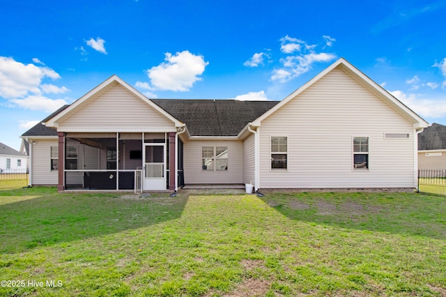 rear view of property with a lawn, fence, and a sunroom