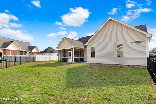 rear view of house with a sunroom, a fenced backyard, and a yard