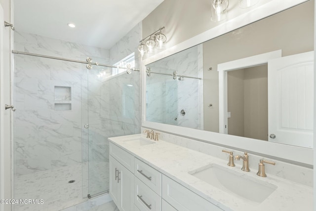 full bathroom with marble finish floor, a sink, a marble finish shower, and double vanity