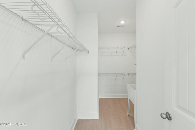 walk in closet with wood finished floors and visible vents