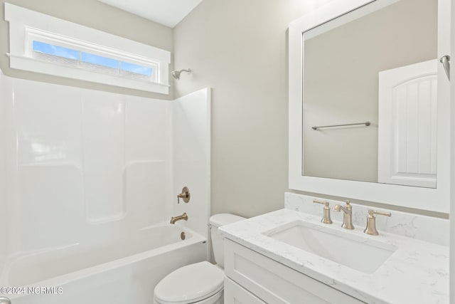 bathroom with tub / shower combination, vanity, and toilet