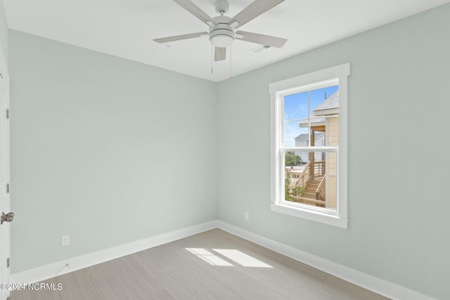 empty room with ceiling fan, light wood-style flooring, and baseboards