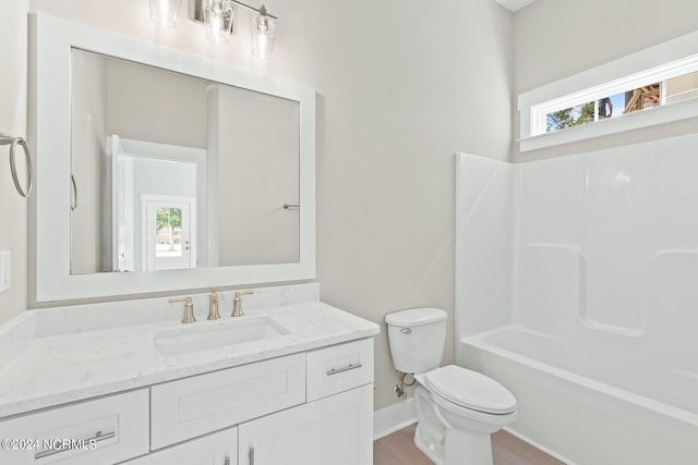 bathroom with baseboards, vanity, toilet, and wood finished floors