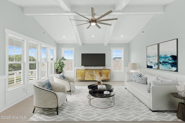 living room with visible vents, wainscoting, lofted ceiling with beams, and wood finished floors