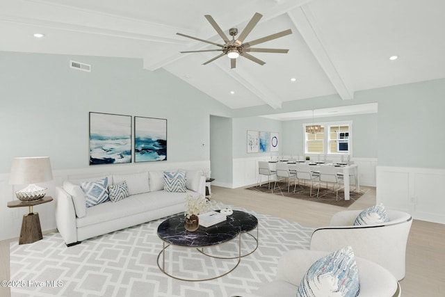 living area with vaulted ceiling with beams, light wood-style flooring, wainscoting, and visible vents