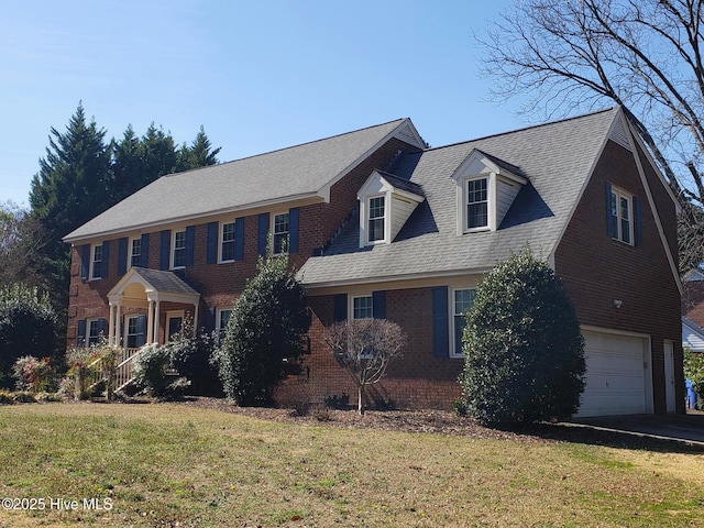 view of front of property with an attached garage, roof with shingles, a front lawn, and brick siding