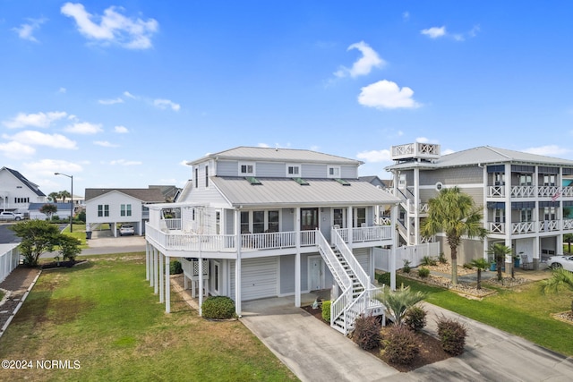 exterior space featuring driveway, metal roof, stairway, and a front lawn