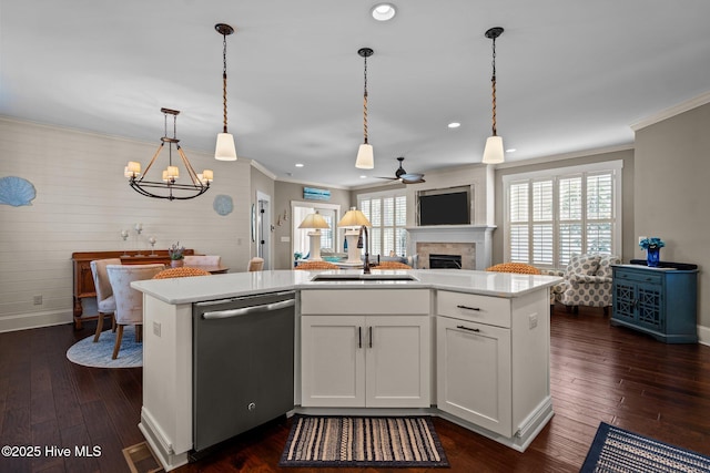 kitchen with dishwasher, light countertops, a sink, and a center island with sink