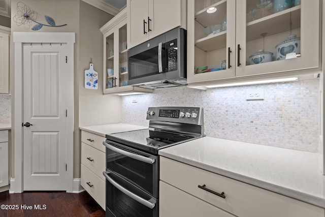 6430 Craller Way, Ocean Isle Beach, NC 28469 - kitchen featuring appliances with stainless steel finishes, dark wood-type flooring, decorative backsplash, glass insert cabinets, and crown molding