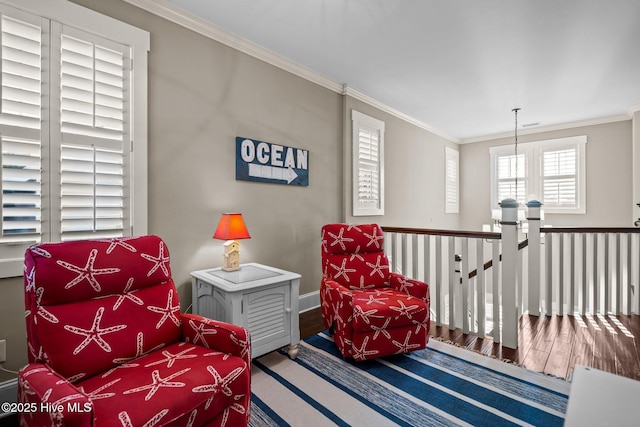 sitting room featuring baseboards, crown molding, an upstairs landing, and wood finished floors