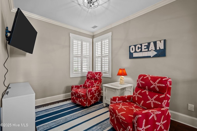 living area with baseboards, visible vents, and crown molding