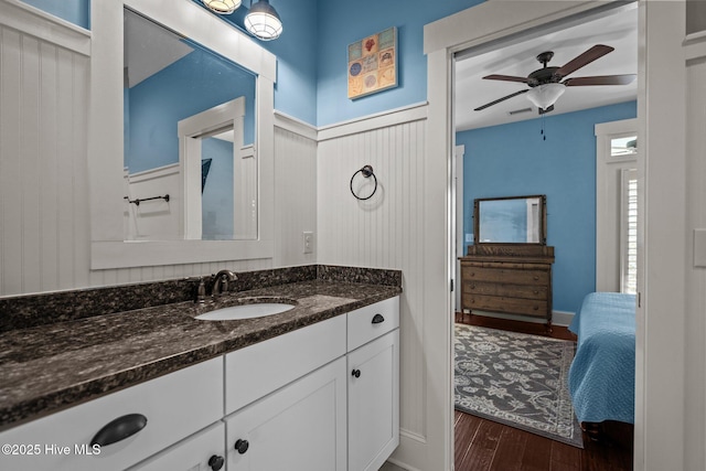 bathroom with wainscoting, ceiling fan, wood finished floors, and vanity